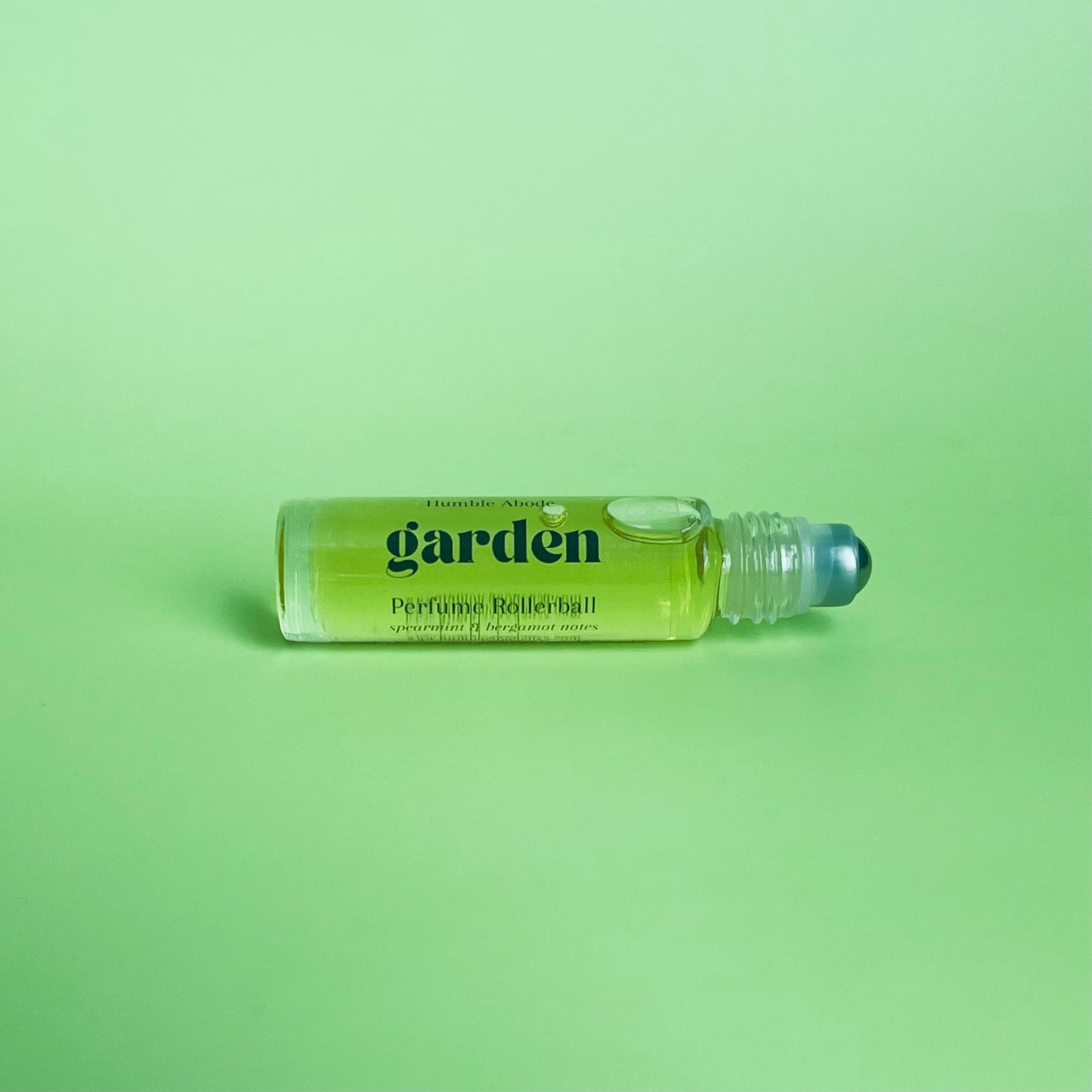 Garden perfume rollerball laying on its side revealing its metal rollerball