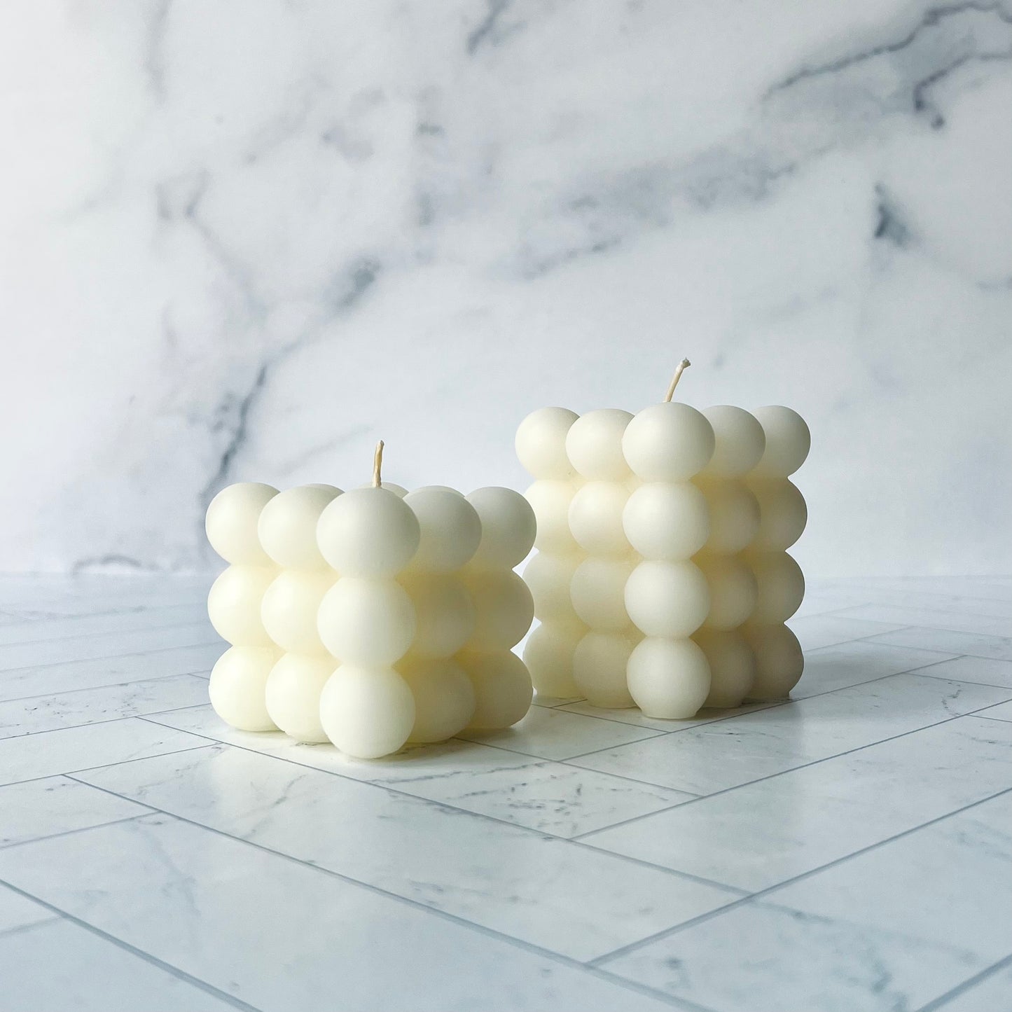 The small and large white bubble beeswax candles shown at an angle