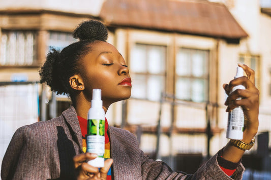 A woman spraying her face with a facial mist