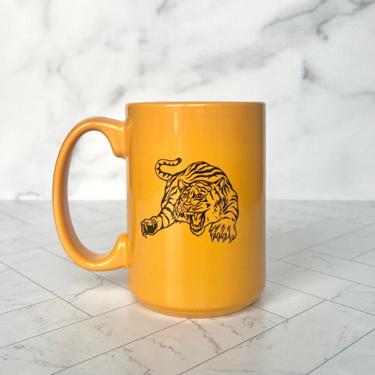 A bright yellow ceramic mug with a retro illustration of a tiger printed on it in black
