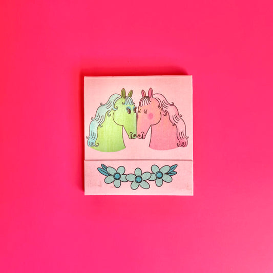 Front of horse matchbook depicting two illustrated, colorful horses 