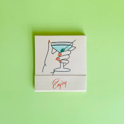 Martini matchbook front featuring a drawing of a hand holding a dirty martini