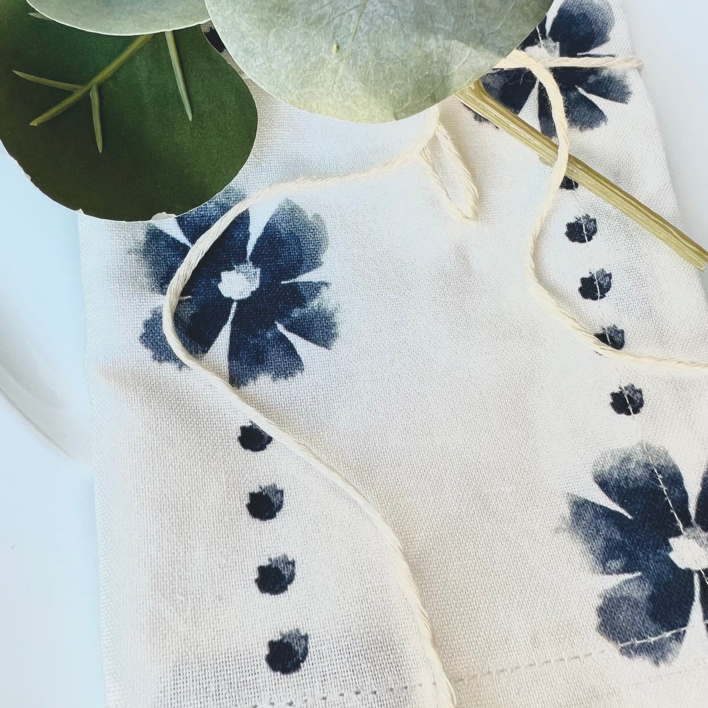 A close-up of one cloth napkin showing a blue daisy-and-dots design