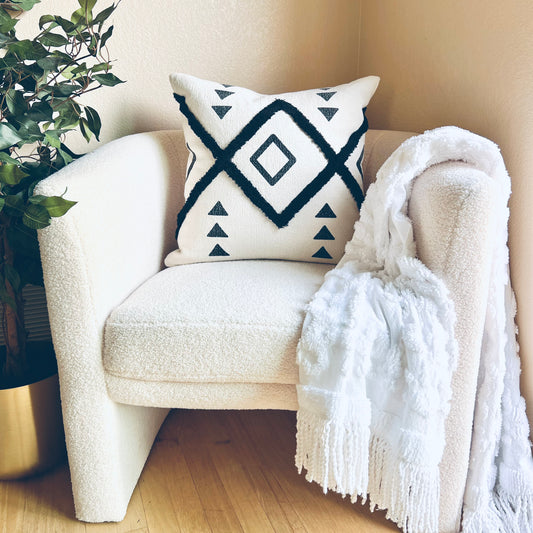 Black and White Pillow situated on a white accent chair