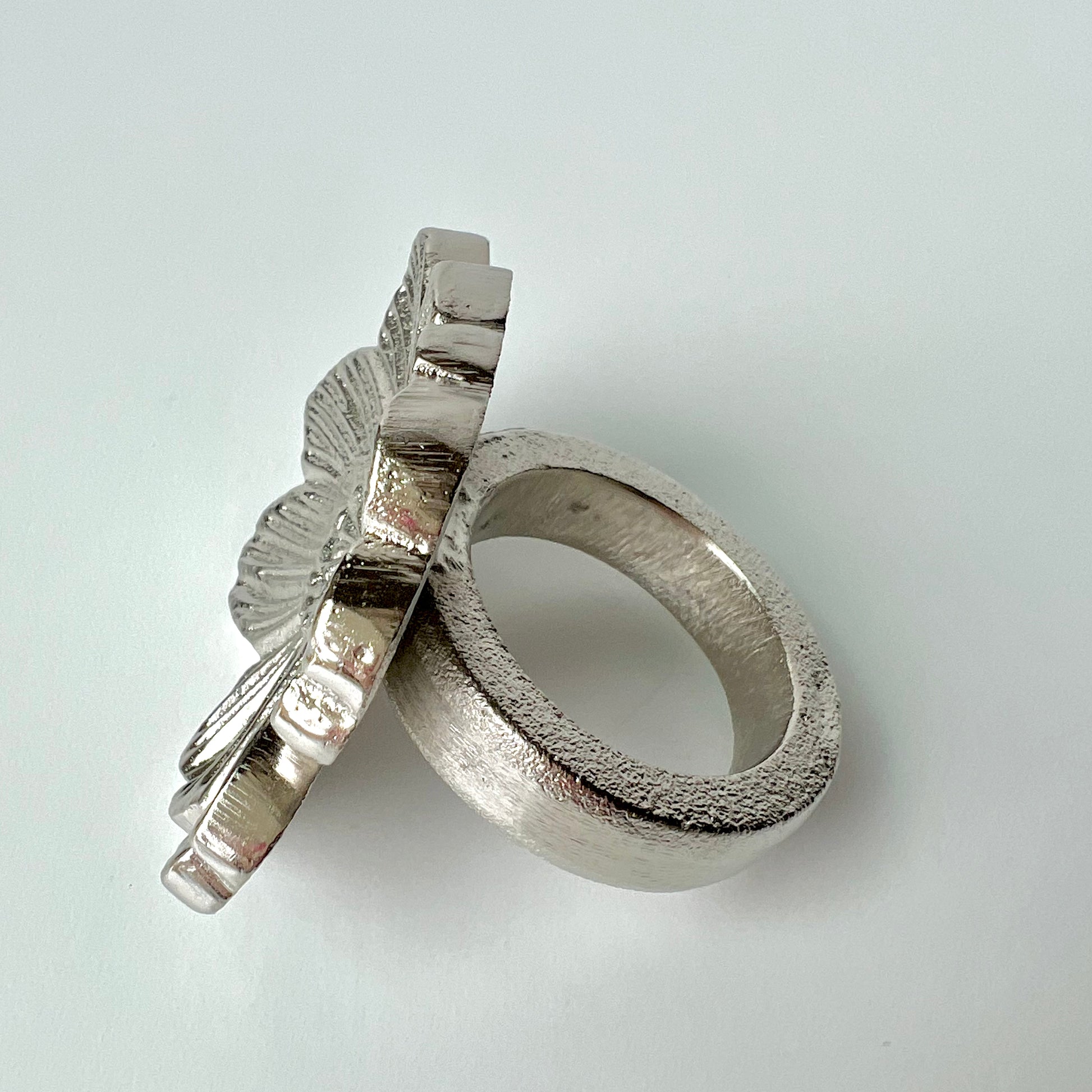 A single silver flower napkin ring shown up close to see its shape and texture