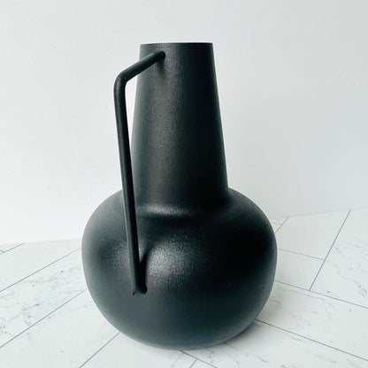 The Sleek Bud Vase on a light surface showing its handle and shape up close