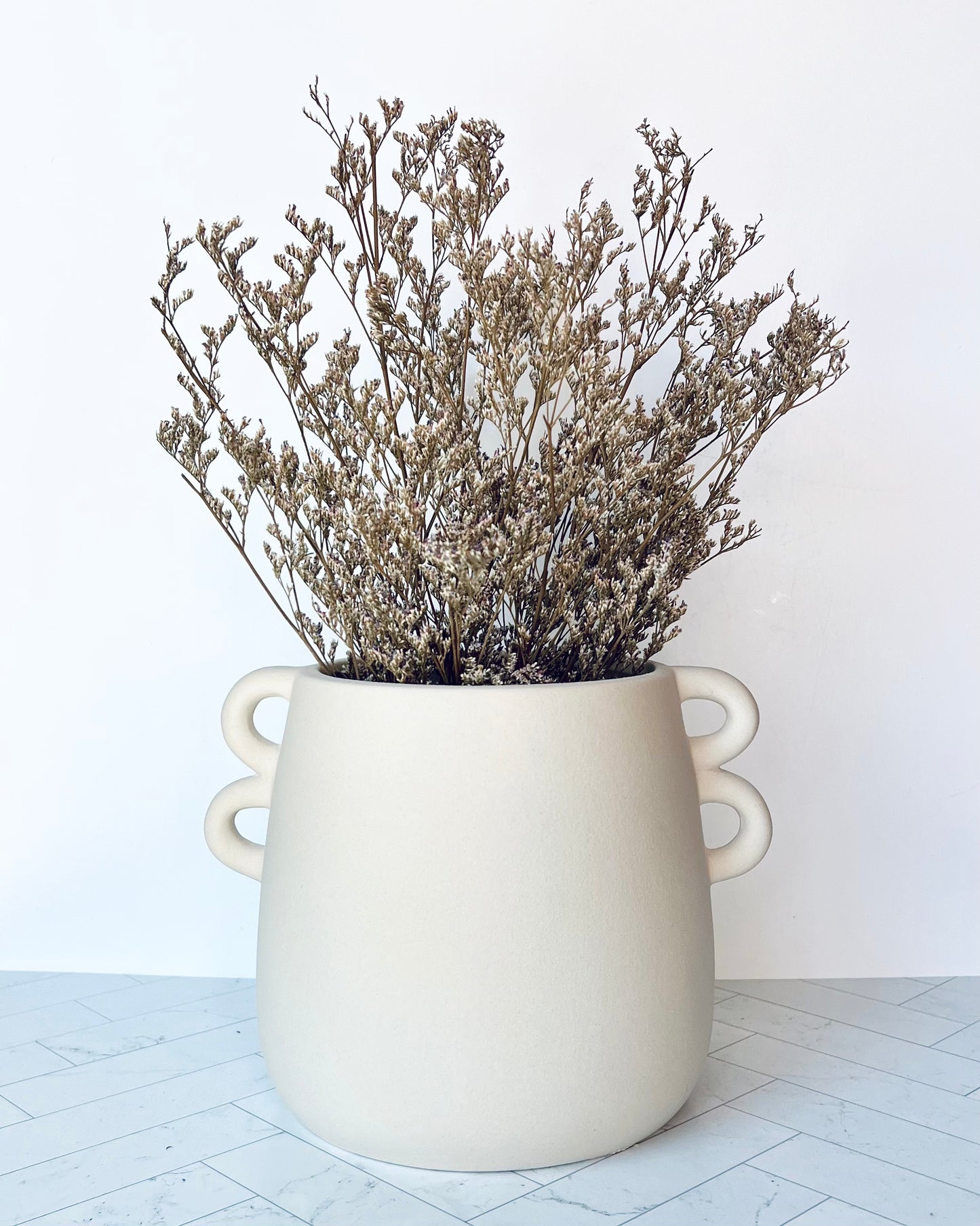 The Chiara White Vase filled with dried flower stems