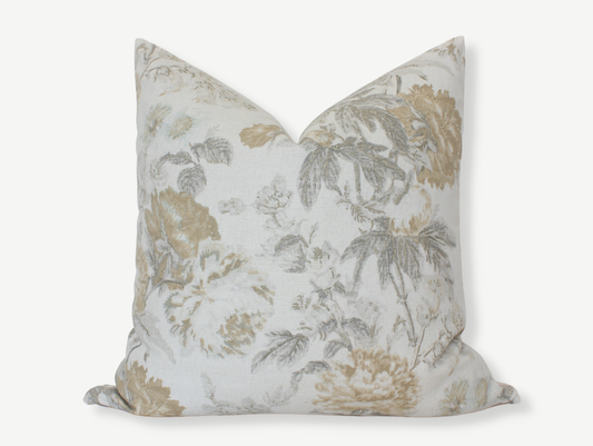 A pillow cover shown with insert against a blank background. Pillow cover shows large flowers in light grays, beiges and yellows against a white background