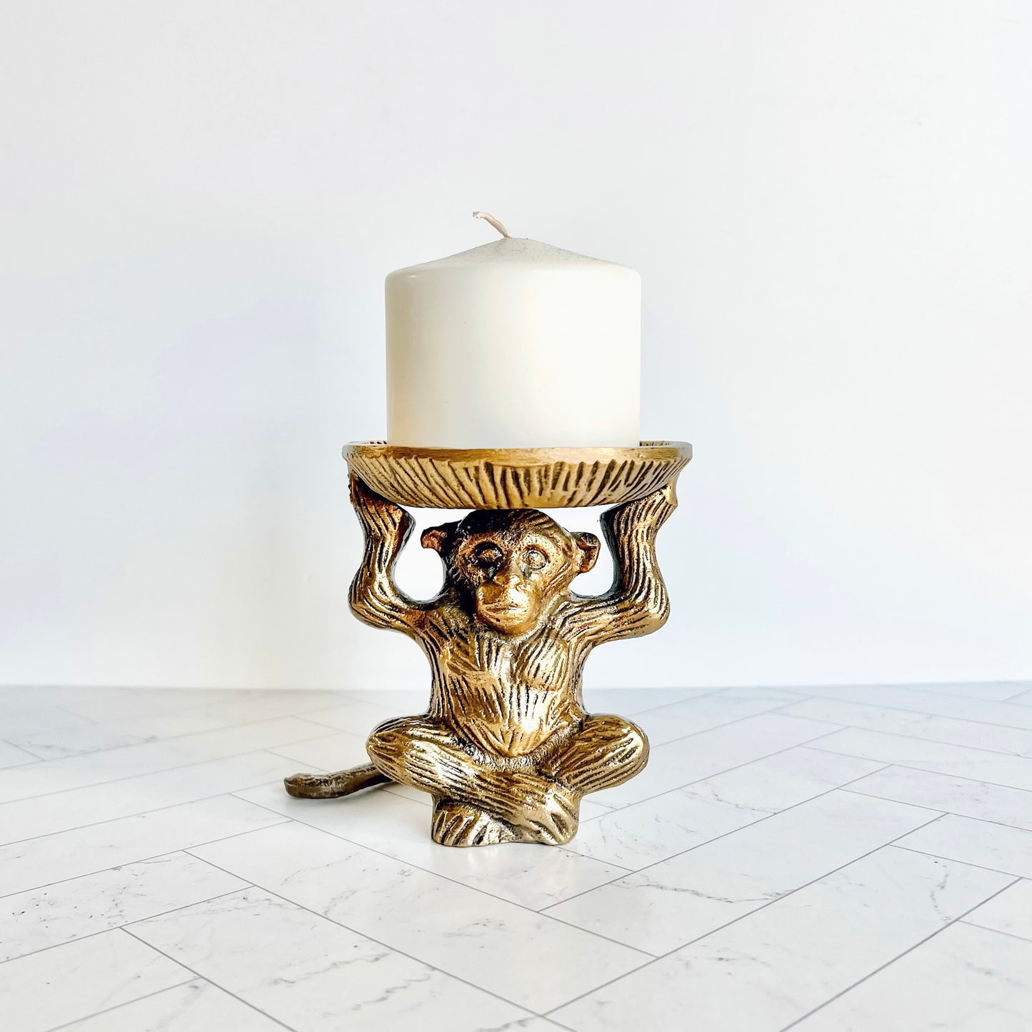The brass animal figurine shown holding a pillar candle