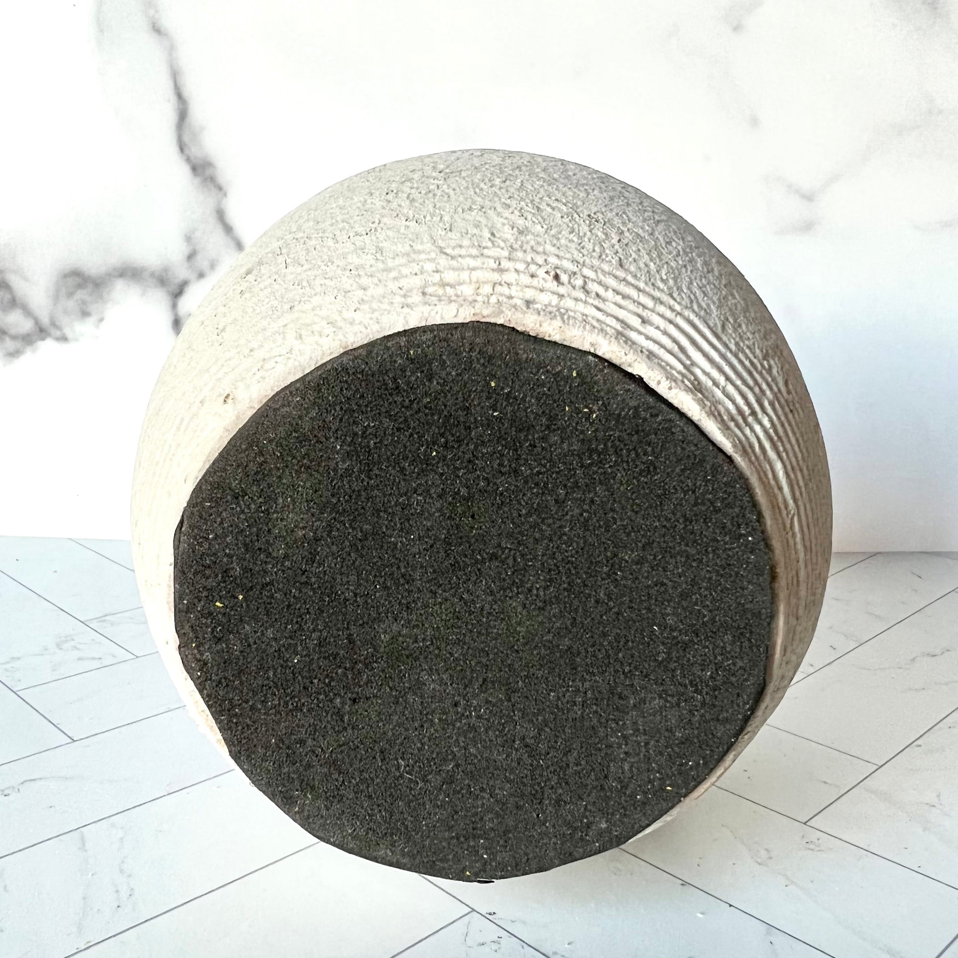 The bottom of a gray vase showing black foam