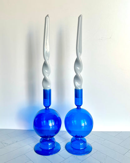 Two Cobalt Candlesticks shown together filled with twisted taper candles