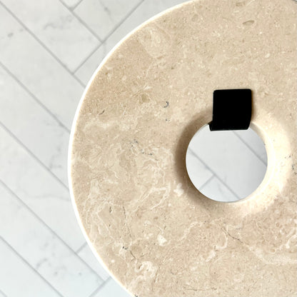 A close up of the beige marble disc showing its color and striation