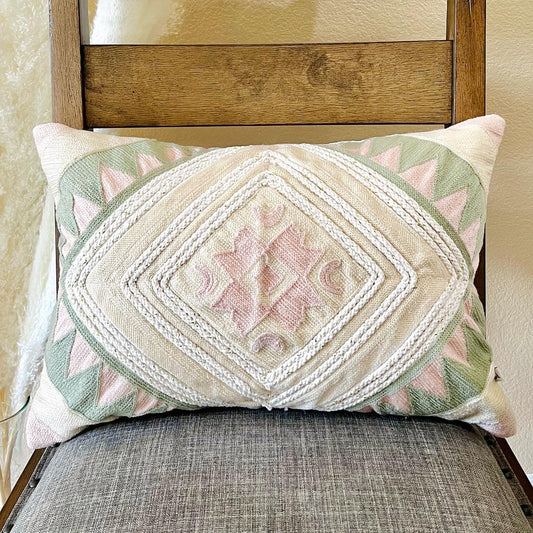 The Blushing Boho Pillow Cover sitting on a chair