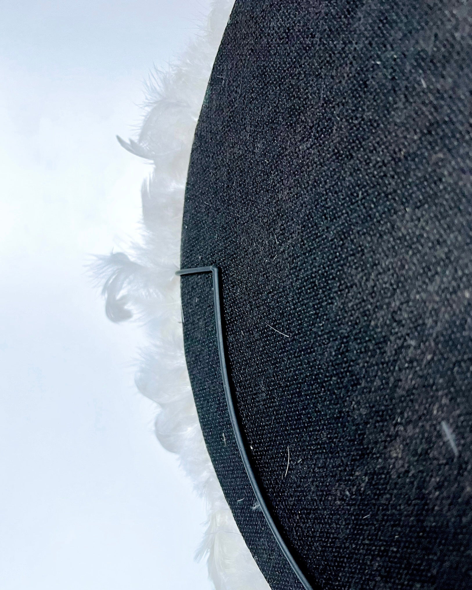 The back of the juju feathers showing how the feathers and shells are mounted to a black back