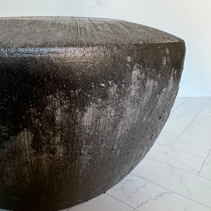 A gray planter with black dripping down the sides