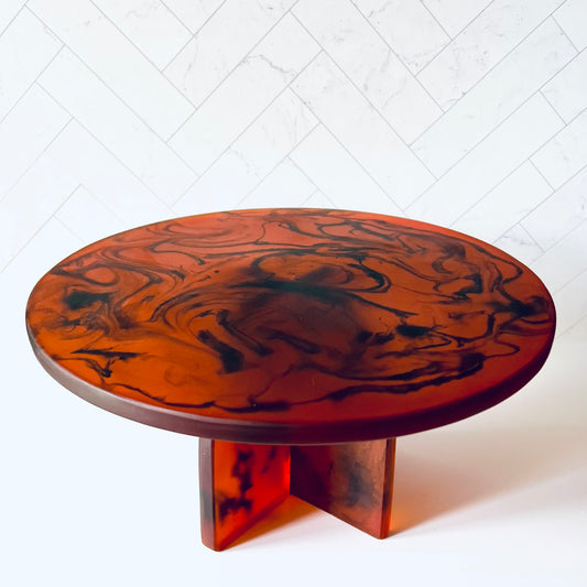 A brown marbled (with black) cake stand on a white surface