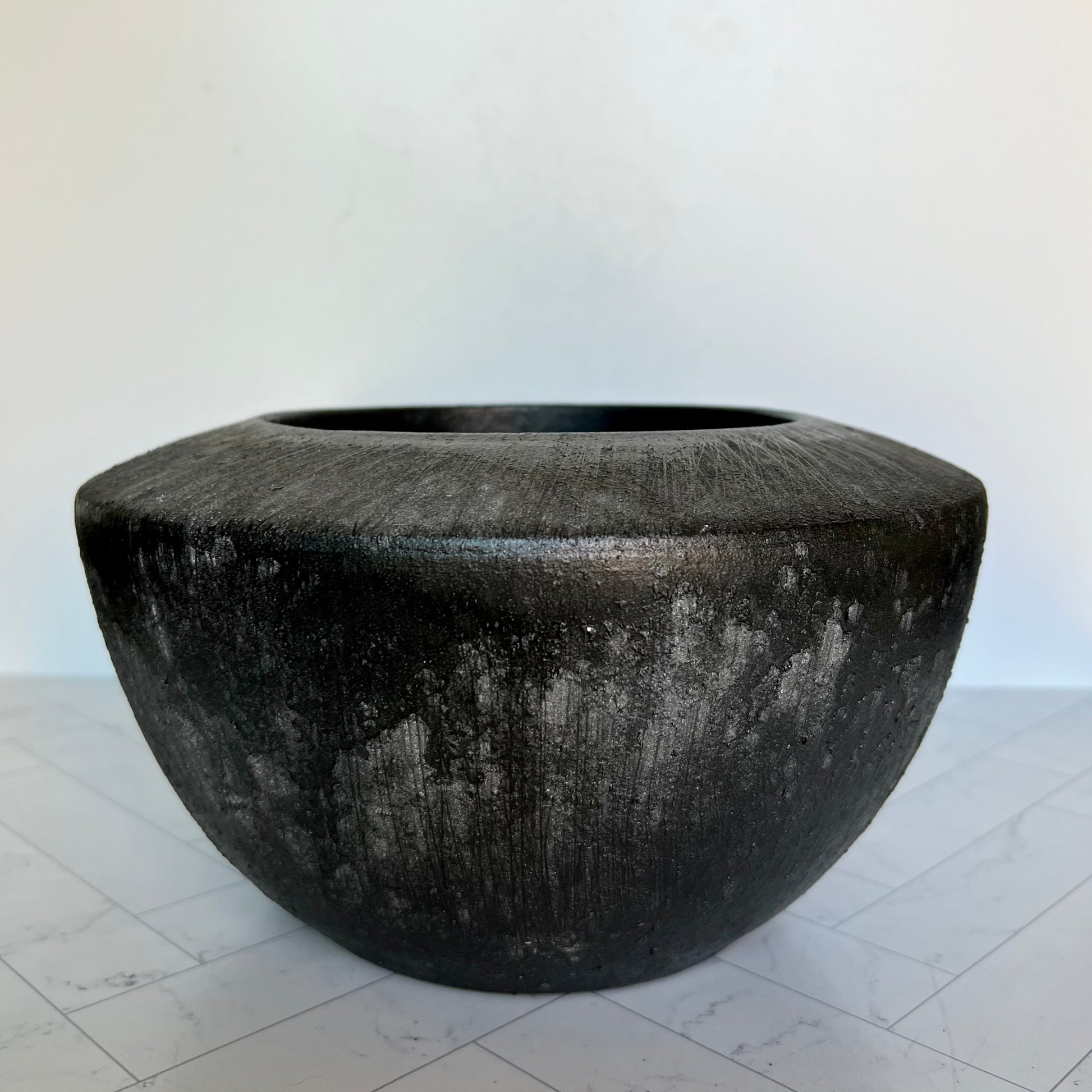 A black/gray planter on a white surface