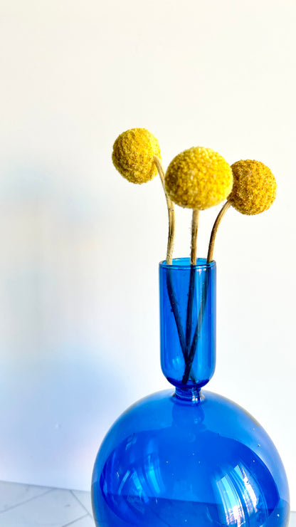 Cobalt Candlestick filled with yellow dried billy button flowers